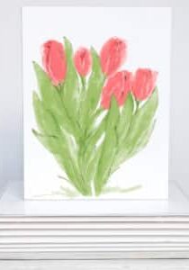 a bunch of red tulips on a note card